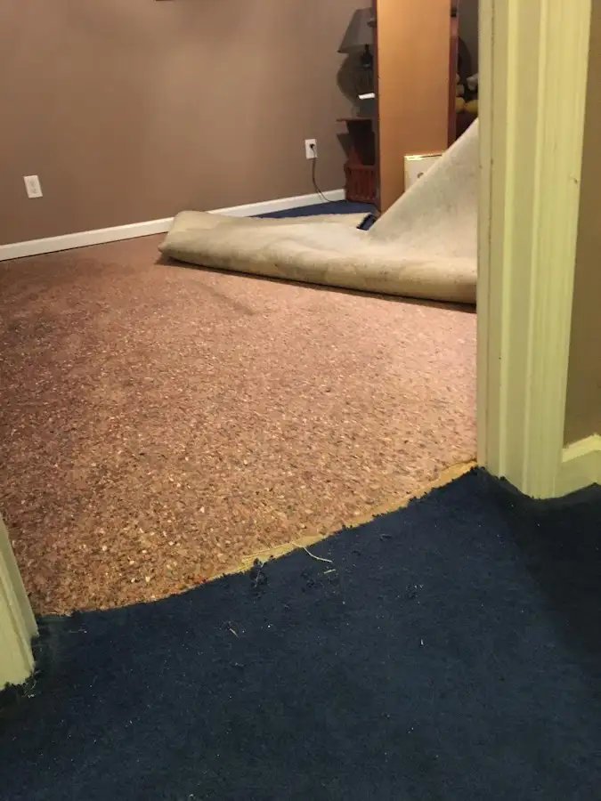 Carpet pad removal revealing water damage during Water Mitigation Services in Southport